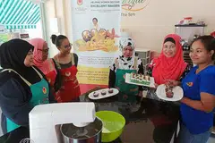 BUKA KAFE: Minat yang mendalam telah mendorong Cik Siti Sabariah Ngah (dua dari kanan, bertudung merah) untuk menjadi cef dan membuka kafe Chef Boutique. - Foto BM oleh SAINI SALLEH