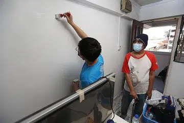 HARGAI JASA: Encik Mohamed Euno (kiri) berkata beliau gembira kerana mendapat bantuan relawan untuk membersihkan rumahnya sempena Tahun Baru Cina. Bersamanya ialah seorang relawan Habitat for Humanity, Xi Wenhan. - Foto BH oleh SAMUEL ANG 