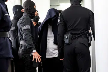 HADAPI TUDUHAN BUNUH: Pegawai kanan polis, Mohd Nazri Abdul Razak, menutup kepalanya dengan jaket hitam, pada 18 Disember. Dia didakwa di Mahkamah Majistret atas tuduhan membunuh seorang pelajar sekolah menengah pada 15 Disember.