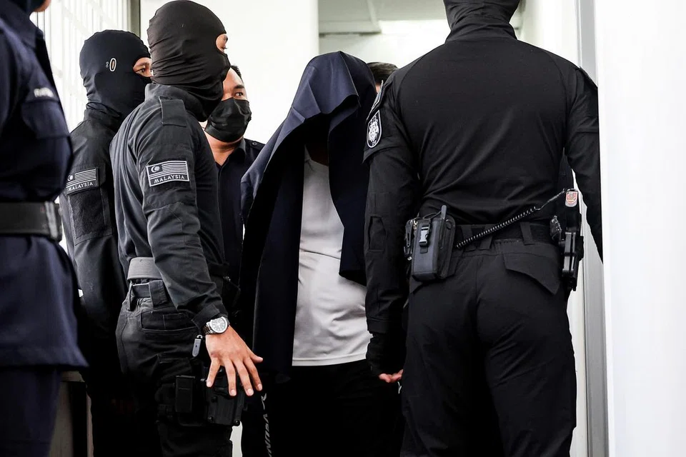 HADAPI TUDUHAN BUNUH: Pegawai kanan polis, Mohd Nazri Abdul Razak, menutup kepalanya dengan jaket hitam, pada 18 Disember. Dia didakwa di Mahkamah Majistret atas tuduhan membunuh seorang pelajar sekolah menengah pada 15 Disember.