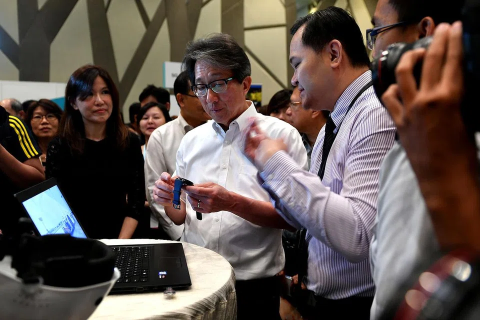 MELAWAT PAMERAN KERJAYA: Menteri Tenaga Manusia Lim Swee Say (dua dari kanan) melihat jam tangan bijak semasa pameran kerjaya di Hotel Crowne Plaza di Lapangan Terbang Changi bulan lalu. - Foto fail