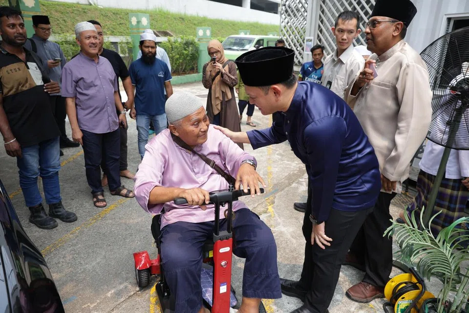 Pemangku Menteri Bertanggungjawab bagi Ehwal Masyarakat Islam, Encik Zaqy Mohamad (kanan), berinteraksi bersama jemaah selepas sesi pertama solat Jumaat pada 9 Oktober di Masjid Ar-Raudhah.