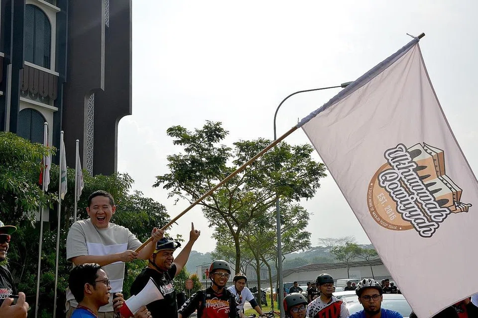 PERANGI DADAH: Sebagai sebahagian daripada kempen 'Dadah itu Haram', Masjid Yusof Ishak bersama Flowriders menganjurkan sesi berbasikal, 'Cycling Away from Drugs', bagi belia Melayu/Islam bersama keluarga mereka pada September lalu. Setiausaha Parlimen Kanan (Ehwal Dalam Negeri merangkap Kesihatan), Encik Amrin Amin (kiri), mengibarkan bendera bagi memulakan acara itu. - Foto MASJID YUSOF ISHAK