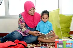 PRIHATIN PENDIDIKAN ANAK: Cik Suriyati Saidi gembira melihat anaknya Siti Hajar Rahmat menunjukkan perkembangan cukup memberangsangkan setelah mengikuti tadika selama setahun di bawah Tadika MOE di Sekolah Rendah Riverside. - Foto KHALID BABA
