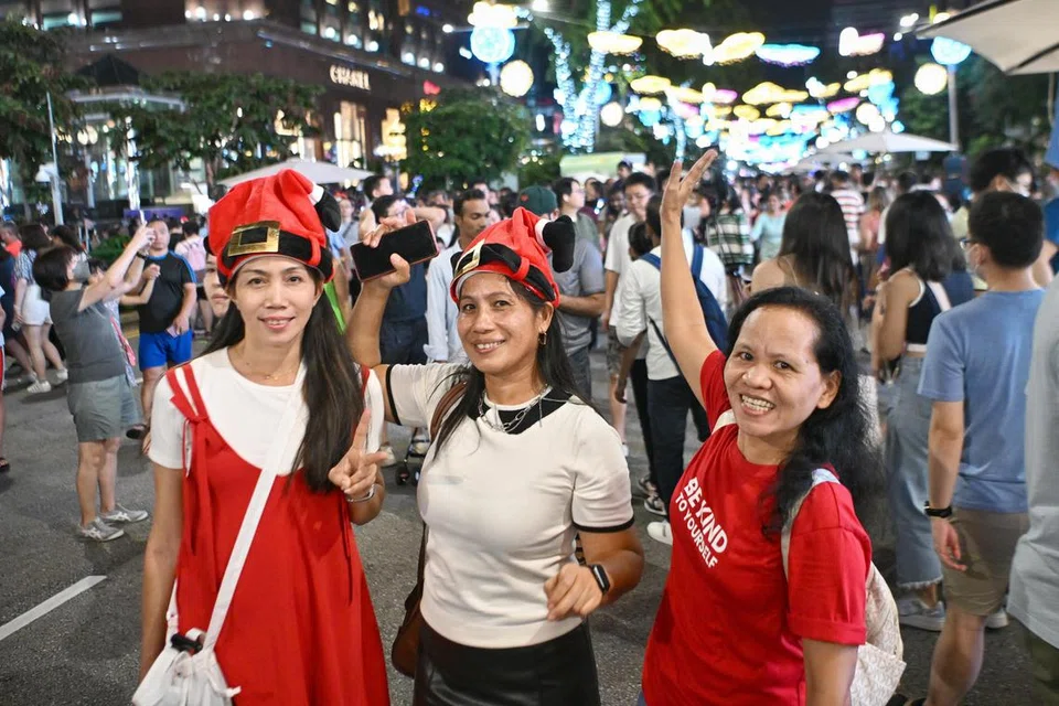 SAMBUT BERSAMA RAKAN: (dari kiri) Cik Lydia Lundubian, Cik Julie Gelongo, dan Cik Premia Tomas sama-sama turun padang ke Orchard Road untuk menyertai pesta jalanan yang pertama di kawasan pusat beli-belah paling terkenal di Singapura itu pada malam Hari Natal.