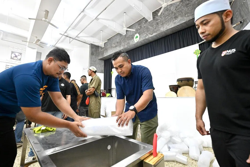 Ustaz Tamliikhaa Khamsani (kanan) antara pelatih di sesi latihan penyembelihan haiwan korban anjuran Aliyah Rizq Holdings, di Rumah Peralihan Pertapis pada 16 Mei. Anggota Parlimen (AP) GRC Pasir Ris-Changi, Encik Sharael Taha (dua dari kanan), merupakan antara sukarelawan yang mengikuti latihan itu.