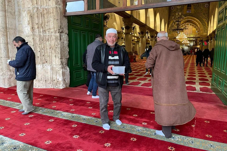 Seorang anggota jemaah di Masjid Al-Qibli mengagihkan kurma kepada jemaah lain sebelum waktu berbuka puasa. 