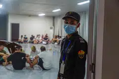 Seorang pengawal keselamatan berdiri berjaga di sebelah sebuah bilik yang dipenuhi individu yang didakwa sebagai pekerja dan mangsa pusat penipuan siber semasa operasi pembanterasan oleh Pasukan Pengawal Sempadan Karen (BGF) terhadap aktiviti haram di Shwe Kokko, daerah Myawaddy di timur Myanmar pada 14 Februari 2025. Sebuah kumpulan pemberontak di Myanmar memaklumkan pada 15 Februari bahawa mereka sedang bersiap sedia untuk menghantar pulang 10,000 individu yang terlibat dalam operasi penipuan siber di kawasan di bawah kawalan mereka sebagai sebahagian daripada usaha berterusan membanteras kegiatan haram tersebut