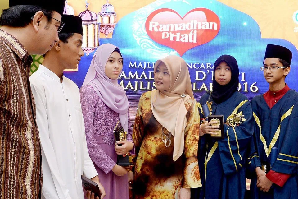 NUCAPAN TAHNIAH: Cik Rahayu Mahzam (tiga dari kiri) berbicara dengan antara pelajar terbaik pengajian Islam di majlis Haflah Madrasah sempena pelancaran Program Keagamaan Jamiyah, Ramadhan D'Hati. Bersamanya ialah Presiden Jamiyah, Dr Hasbi Abu Bakar (dikiri). Para pelajar ini ialah (mulai dua dari kiri) Muhammad Raziq Mohd Noor; Nur Insyirah Imam Mujtahid, Nur Sabrina Abu Bakar dan Abdul Rahman Azhar. - Foto TAUFIK A. KADER