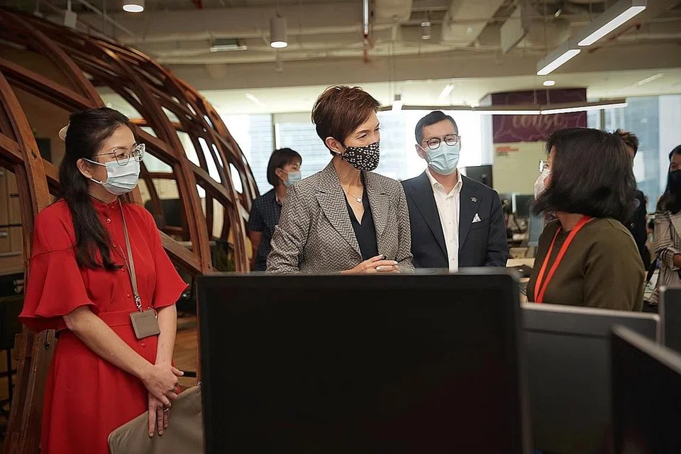 LAKUKAN LAWATAN: Cik Josephine Teo sedang berinteraksi dengan beberapa pekerja Prudential Singapore semasa dalam lawatannya ke pejabat syarikat itu semalam. - Foto BH oleh GIN TAY