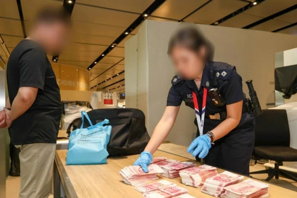 Seorang pegawai ICA sedang menjalankan pemeriksaan ke atas pengembara yang membawa wang tunai ke Singapura semasa operasi pelbagai agensi selama seminggu.