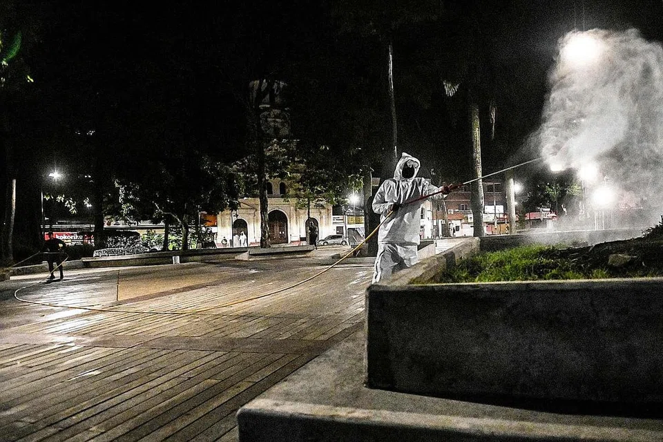 KIAN TULAR: Seorang pegawai keselamatan di Colombia menyembur cecair nyah kuman di sebuah taman di negara Amerika Tengah itu. Lebih 20,000 kes Covid-19 dicatat di Amerika Latin dan Caribbean menjelang kelmarin, menurut pengiraan AFP menggunakan data pihak berkuasa nasional dan WHO. - Foto AFP