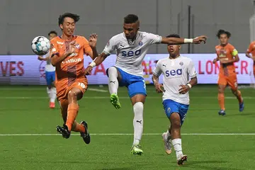 SIAPA LEBIH HANDAL?: Pemain Lion City Sailors Nur Adam Abdullah (tengah) saling berebut bola dengan pemain Albirex Niigata Fumiko Suzuki dalam perlawanan pada April lalu. - Foto BH oleh KHALID BABA