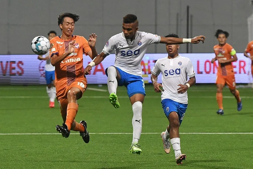 SIAPA LEBIH HANDAL?: Pemain Lion City Sailors Nur Adam Abdullah (tengah) saling berebut bola dengan pemain Albirex Niigata Fumiko Suzuki dalam perlawanan pada April lalu. - Foto BH oleh KHALID BABA