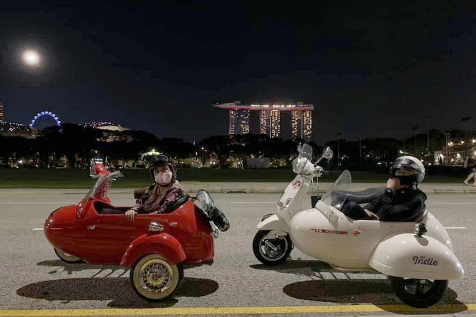 ULANG TAHUN TETAP ISTIMEWA: Walaupun tidak dapat meraikan ulang tahun perkahwinan mereka di luar negara, Cik Jurinah dan suami Encik Helmie dapat menikmati keindahan Singapura dengan menaiki skuter Vespa vintaj berkereta tepi dari Singapore Side Cars. - Foto ihsan JURINAH SOKIR