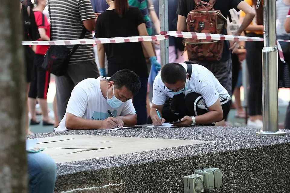 PASTIKAN BEBAS KORONAVIRUS: Penumpang yang bakal berangkat ke China beratur untuk mengambil ujian Covid-19 di bekas Sekolah Menengah Shuqun semalam, bagi memenuhi syarat yang ditetapkan oleh negara itu. - Foto BH oleh TIMOTHY DAVID