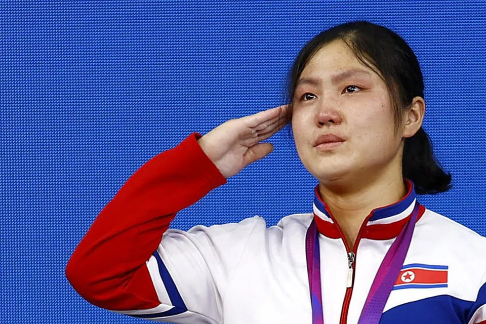 KEPULANGAN BERHARGA: Reaksi atlet Korea Utara Kim Il Gyong semasa upacara penyampaian pingat emas dalam acara angkat berat 59 kilogram wanita. Sukan Asia Hangzhou ialah temasya sukan antarabangsa pertama yang dihadiri Korea Utara sejak edisi 2018 di Jakarta. Korea Utara telah digantung daripada Jawatankuasa Olimpik Antarabangsa (IOC) sehingga akhir 2022, terlepas beraksi dalam Sukan Olimpik Musim Sejuk Beijing tahun lalu, selepas gagal menghantar pasukan ke Sukan Olimpik Musim Panas di Tokyo.