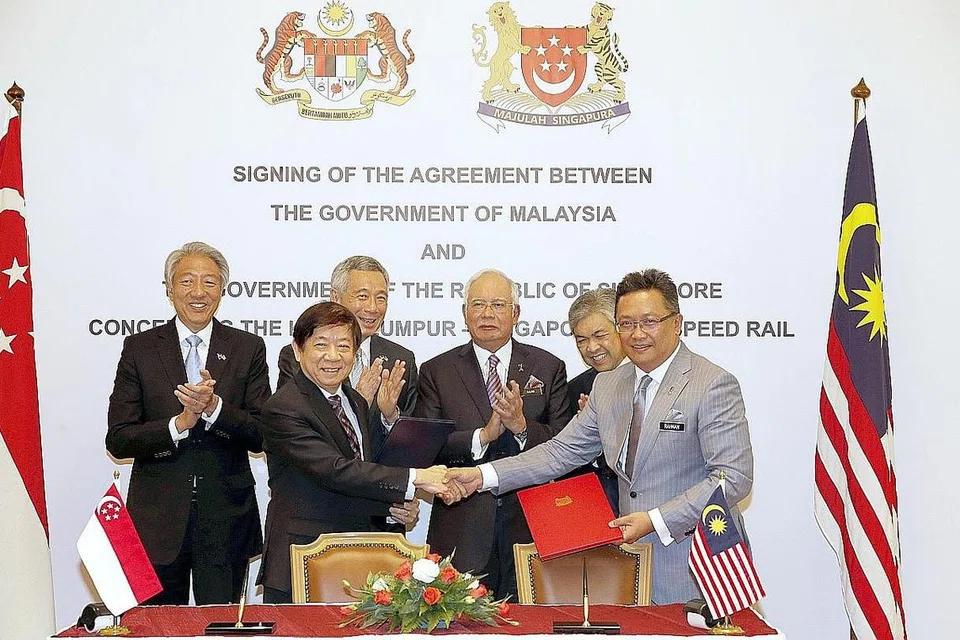 METERAI PERJANJIAN: Perdana Menteri Lee Hsien Loong (barisan belakang dua dari kiri) dan Perdana Menteri Malaysia, Datuk Seri Najib Tun Razak (barisan belakang tiga dari kiri), bersama menyaksikan pertukaran dokumen selepas Majlis Menandatangani Perjanjian Dua Hala Khidmat Rel Laju (HSR) antara Menteri Di Jabatan Perdana Menteri Malaysia, Datuk Abdul Rahman Dahlan (di hadapan kanan), dengan Menteri Penyelaras Prasarana yang juga Menteri Pengangkutan, Encik Khaw Boon Wan (di hadapan kiri), di Bangunan Perdana Putra, Putrajaya, semalam. Turut kelihatan Timbalan Perdana Menteri, Encik Teo Chee Hean (kiri), dan Timbalan Perdana Menteri Malaysia, Datuk Seri Dr Ahmad Zahid Hamidi (di belakang kanan). - Foto THE STRAITS TIMES