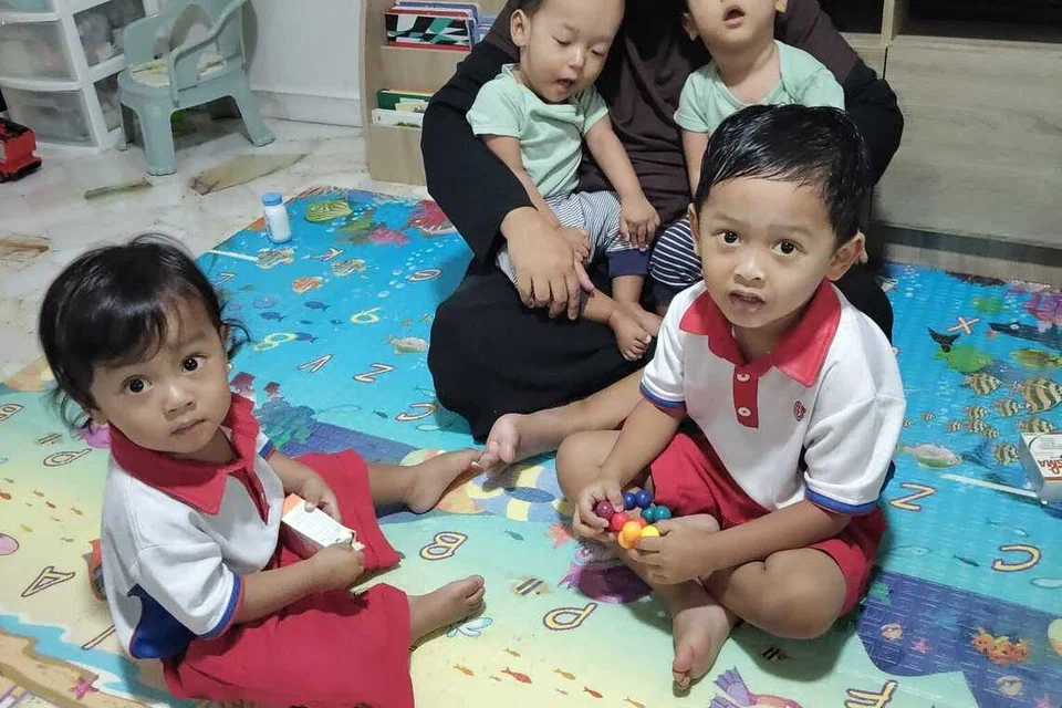 Cik Nadzihar Nor Azman, bersama dua anak kembarnya yang menghidap sindrom penghapusan 1p36, Nuh Khaif Mohamad Khairul (dipangku, kanan) dan Nuh Khaleef Mohamad Khairul (dipangku, kiri). Turut kelihatan ialah anak sulungnya, Nufael Khalish Mohamad Khairul (kanan), serta Naufal Kayden Mohamad Khairul, seorang lagi daripada pasangan kembar tiga itu.