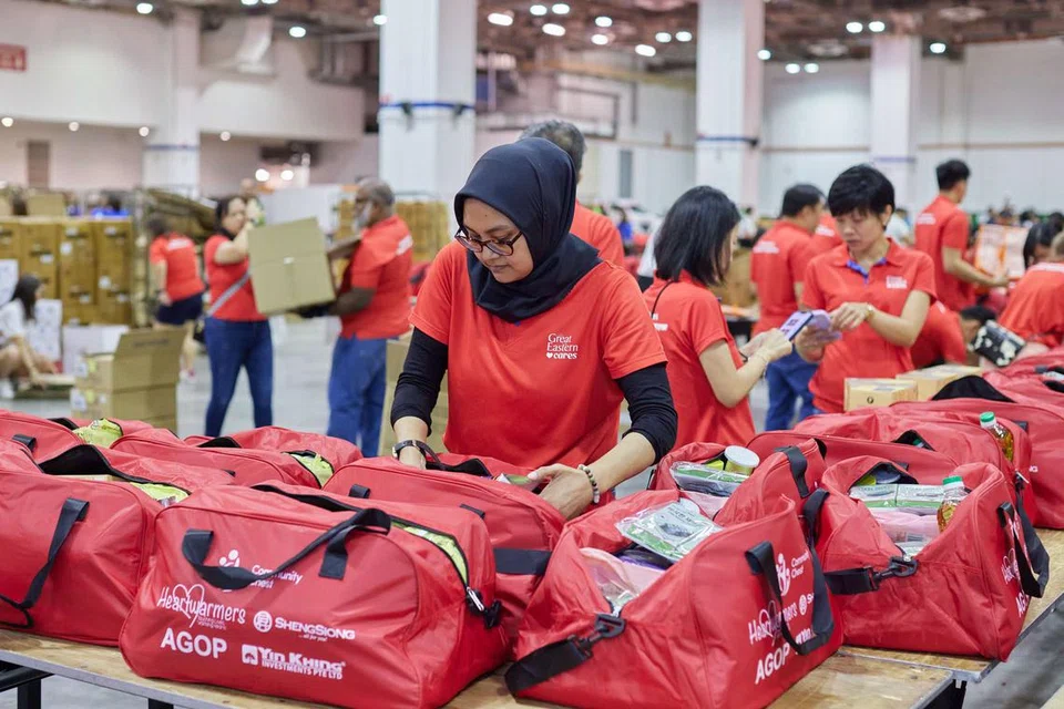 Sukarelawan untuk ‘Habuan Harapan 2025’ membungkus pakej perayaan yang bakal diagihkan kepada 7,000 keluarga di seluruh Singapura.