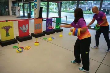 SAMBUT BERSAMA: Relawan Team Nila menunjukkan cara bermain permainan ‘Ring The Landmark’, iaitu salah satu permainan nostalgia yang akan disediakan di Pesta Kejiranan GetActive! Singapura 2023 pada 5 dan 6 Ogos. 