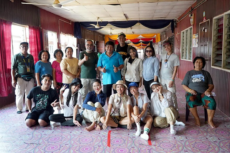 Penulis, Encik Khalid Baba (berdiri, tujuh dari kiri), berkunjung ke rumah panjang orang Iban.