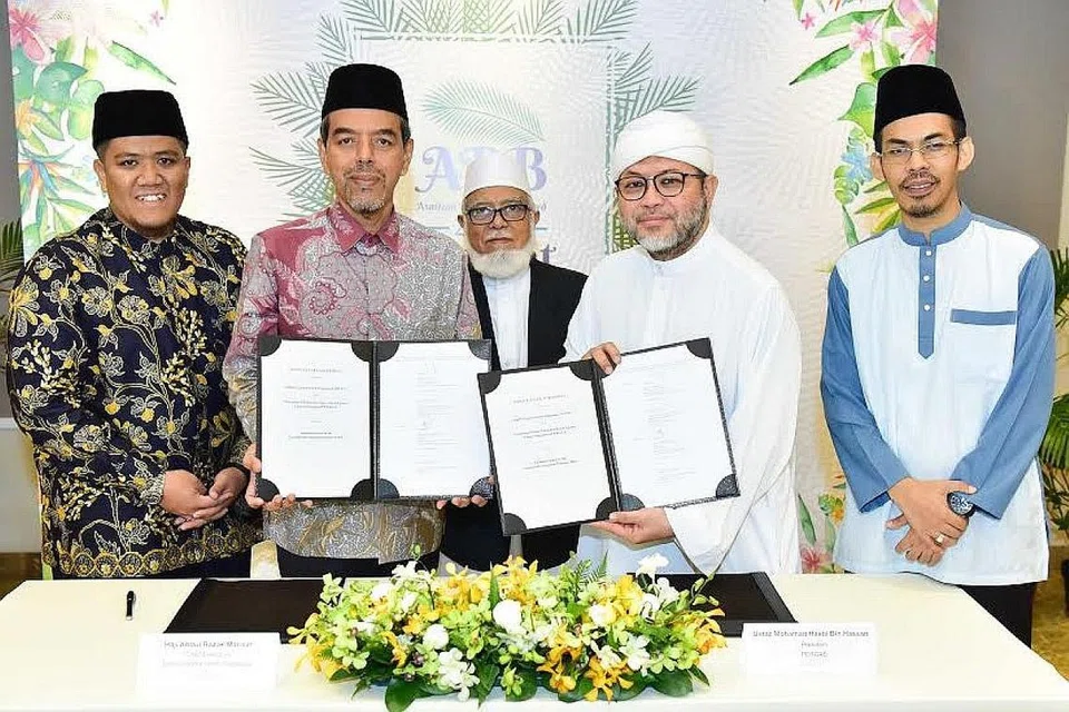 PERKUKUH USAHA: Ketua Eksekutif Muis, Encik Abdul Razak Hassan Maricar (dua dari kiri) dan Presiden Pergas, Ustaz Mohamad Hasbi Hassan (dua dari kanan) memeterai MOU Muis-Pergas. Menyaksikan majlis itu ialah (dari kiri) Timbalan Pengarah, Dasar dan Peraturan Keagamaan Muis, Ustaz Irwan Hadi Mohd Shuhaimy; Mantan Mufti Singapura, Shaikh Syed Isa Mohamed Semait; dan Ketua Pegawai Eksekutif Pergas, Ustaz Mohammad Yusri Yubhi Md Yusoff. - Foto MUIS