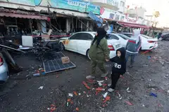 Orang ramai berjalan melepasi sebuah kafe yang rosak akibat serangan Israel di Sidon, Lebanon, 8 April 2026.