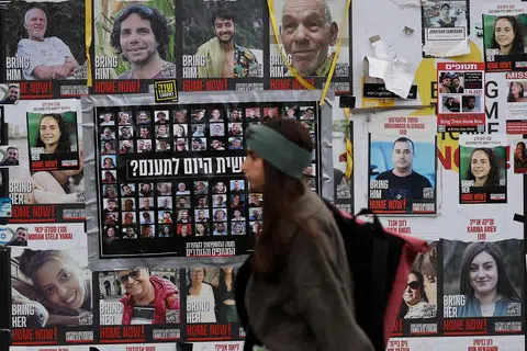 Seorang wanita berjalan melewati poster-poster tebusan yang diculik semasa serangan maut pada 7 Oktober 2023 oleh Hamas, di Tel Aviv, Israel, pada 26 November 2024. 
