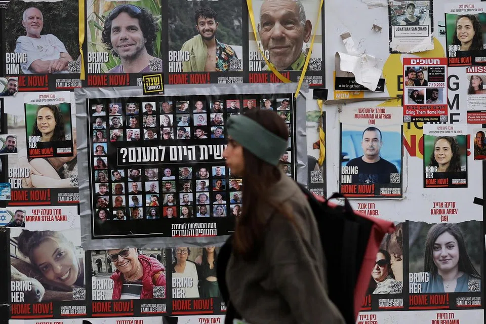 Seorang wanita berjalan melewati poster-poster tebusan yang diculik semasa serangan maut pada 7 Oktober 2023 oleh Hamas, di Tel Aviv, Israel, pada 26 November 2024. 