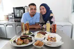 MAKANAN SIHAT: Pengasas syarikat Noor Confinement SG, Cik Siti Rohaini, dan suaminya Encik Salleh menawarkan pelbagai pilihan makanan berkhasiat bagi ibu berpantang yang disiapkan di kilang mereka di Tuas Bay Walk. - Foto BM oleh TIMOTHY DAVID 