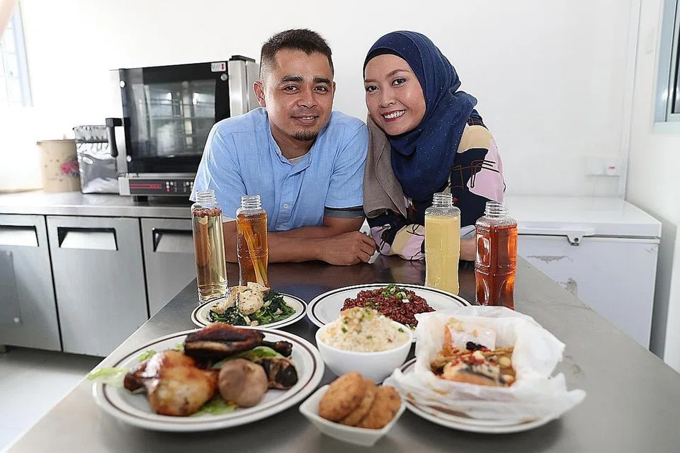 MAKANAN SIHAT: Pengasas syarikat Noor Confinement SG, Cik Siti Rohaini, dan suaminya Encik Salleh menawarkan pelbagai pilihan makanan berkhasiat bagi ibu berpantang yang disiapkan di kilang mereka di Tuas Bay Walk. - Foto BM oleh TIMOTHY DAVID 