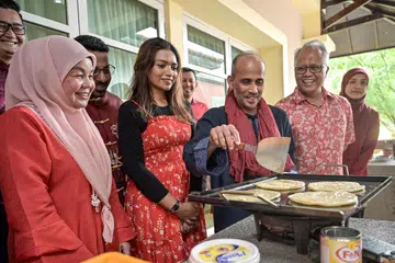 Pesuruhjaya Tinggi Malaysia, Datuk Dr Azfar Mohamad Mustafar (tiga dari kanan) sempat goreng roti canai resipi istimewa yang dibuat secara ‘live’ untuk dinikmati tetamu pada acara sambutan Tahun Baru Cina di Rumah Malaysia pada 17 Februari.