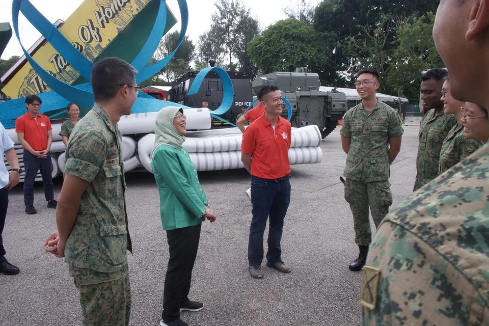 BERAMAH MESRA: Presiden Halimah Yacob beramah mesra dengan anggota SAF yang menyertai segmen Pertahanan Mutlak di NDP 2023 ketika beliau mengunjungi pangkalan kontinjen itu pada Sabtu pagi.