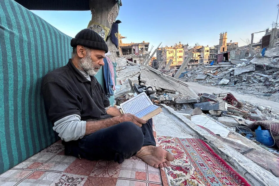Lelaki Palestin ini, Encik Ismail Al-Khlout, membaca Al-Quran sementara menunggu untuk berbuka puasa pada 13 Mac di atas runtuhan rumahnya di Beit Lahia, utara Jaluran Gaza, yang musnah semasa serangan tentera Israel. 