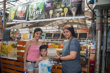 TARIK PELANGGAN PELBAGAI KAUM: Gerai NZ foodies Cik Nazurah Yusof (kanan) yang menjual bebola tepung berinti turut menarik pelanggan bukan Islam.