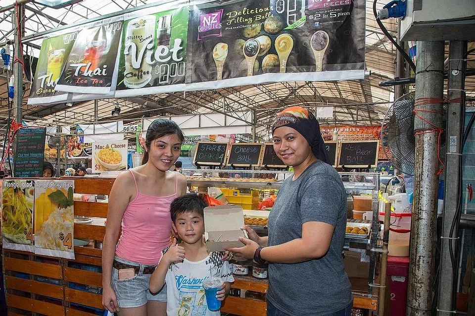 TARIK PELANGGAN PELBAGAI KAUM: Gerai NZ foodies Cik Nazurah Yusof (kanan) yang menjual bebola tepung berinti turut menarik pelanggan bukan Islam.