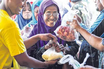SEMANGAT KORBAN MAKMURKAN MASYARAKAT: Penduduk desa dari gunung turun ke stadium Plumbon Pasuruan, Indonesia, menerima sumbangan daging korban dan beras anjuran sebuah pertubuhan islam Singapura. Salah satu ciri ibadah dalam ajaran Islam adalah setiap ibadah pasti memiliki sisi sosial dan ekonominya baik secara langsung mahupun tidak langsung. - Foto IBADAHSG