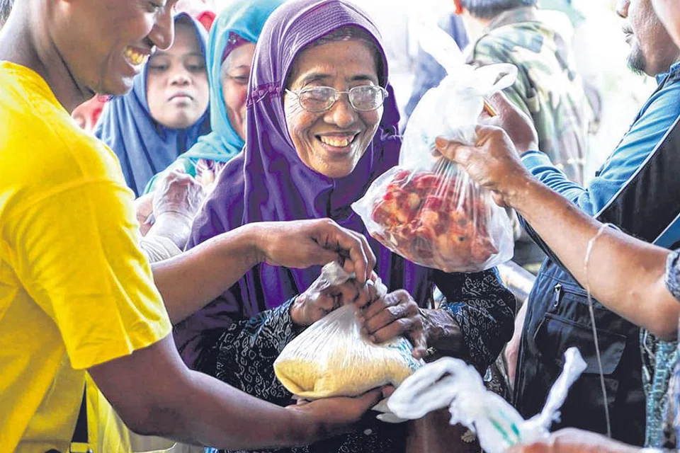 SEMANGAT KORBAN MAKMURKAN MASYARAKAT: Penduduk desa dari gunung turun ke stadium Plumbon Pasuruan, Indonesia, menerima sumbangan daging korban dan beras anjuran sebuah pertubuhan islam Singapura. Salah satu ciri ibadah dalam ajaran Islam adalah setiap ibadah pasti memiliki sisi sosial dan ekonominya baik secara langsung mahupun tidak langsung. - Foto IBADAHSG