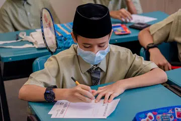 JARANG TULIS KAD HARI BAPA: Pelajar dari Madrasah Al-Arabiah Al-Islamiah (MAI), Mohamed Haikal Mohamed Nazri, menulis ucapan yang bermakna untuk bapanya sempena Hari Bapa. - Foto BM oleh NUR DIYANA TAHA
