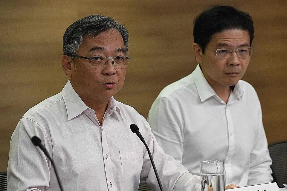 Menteri Kesihatan, Encik Gan Kim Yong (kiri), dan Menteri Pembangunan Negara, Encik Lawrence Wong (kanan). - Foto AFP