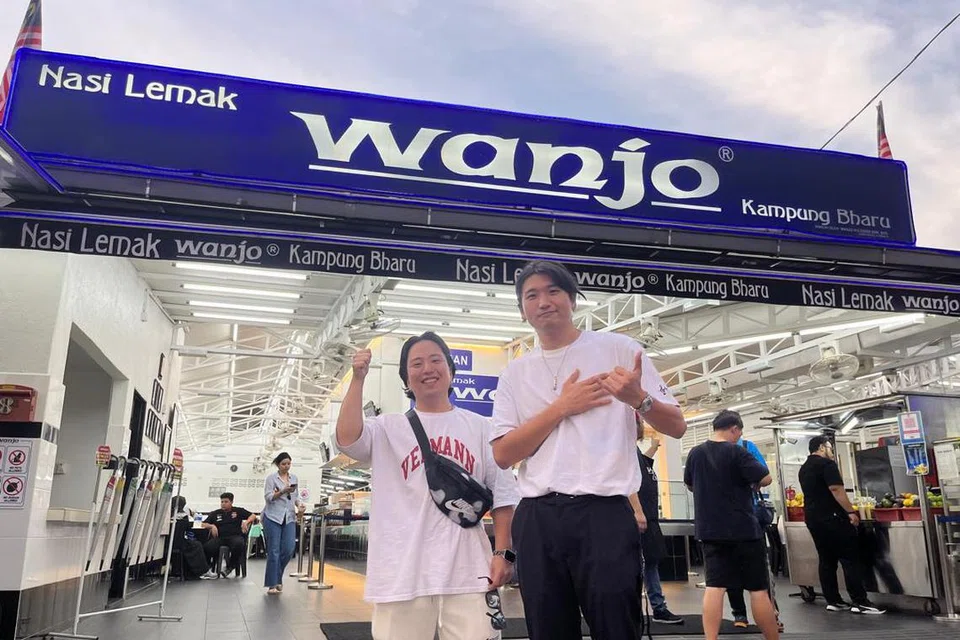Encik Jack Lee, 25 tahun (kiri), dan sahabatnya, Encik Lee Sam, 30 tahun,  yang berasal dari Korea Selatan dan kini bekerja di Singapura gemar  keenakan nasi lemak Wanjo di Kampung Bharu, Kuala Lumpur.