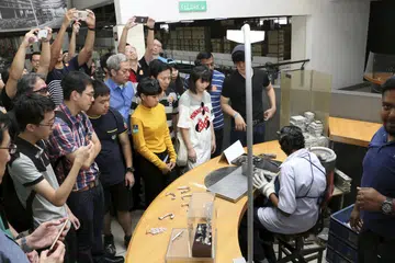MELAWAT ROYAL SELANGOR PEWTER: Pelajar ITE menyaksikan pekerja membentuk piuter yang dicairkan menjadi pelbagai barangan seperti cawan dan bingkai gambar. - Foto ITE