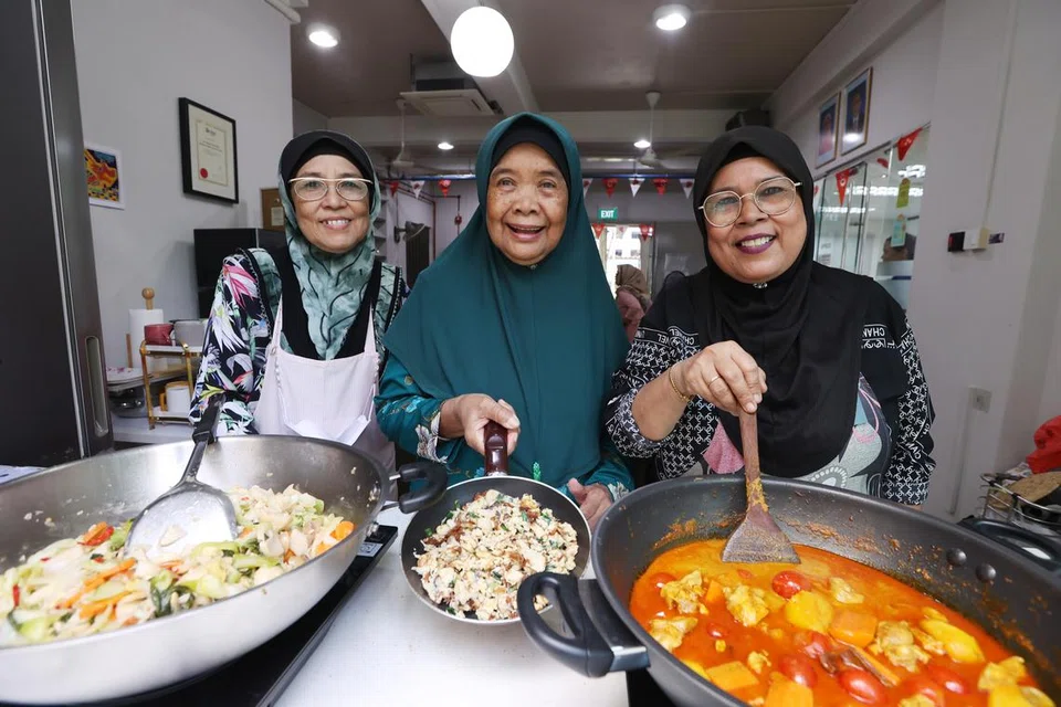 MASAKAN SIHAT: Tiga warga emas, (dari kiri) Cik Aminah Ibrahim, Cik Rosnah Sulaiman dan Cik Fatimah Kalip menggunakan kredit SkillsFuture untuk menyertai kursus kebersihan makanan supaya mereka boleh menyiapkan hidangan untuk warga emas lain. 