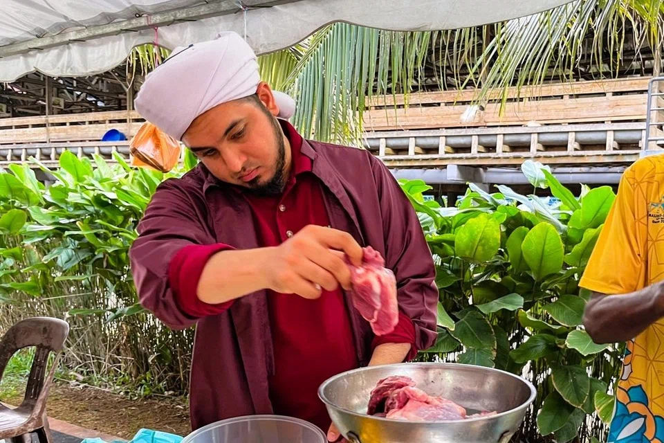 Pengerusi Eksekutif, Erth Al-Mustafa Foundation, Encik Imran Angullia Al-Hafidz, mengagihkan daging korban yang disumbangkan oleh warga Singapura.