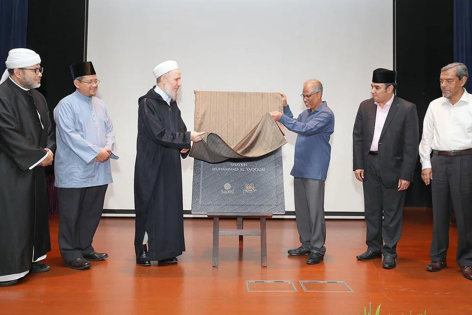 LANCAR BUKU: Shaykh Muhammad Al-Yaqoubi (tiga dari kiri) melancarkan bukunya yang diterjemahkan kepada bahasa Melayu berjudul 'Menyangkal ISIS' sambil dibantu Encik Masagos. Bersama mereka ialah (dari kiri) Presiden Pergas Ustaz Mohamad Hasbi Hassan; Mufti Dr Mohd Fatris Bakaram; Dr Mohamed; dan Ketua Eksekutif Majlis Ugama Islam Singapura (Muis) Haji Abdul Razak Hassan Maricar. - Foto BH oleh JONATHAN CHOO