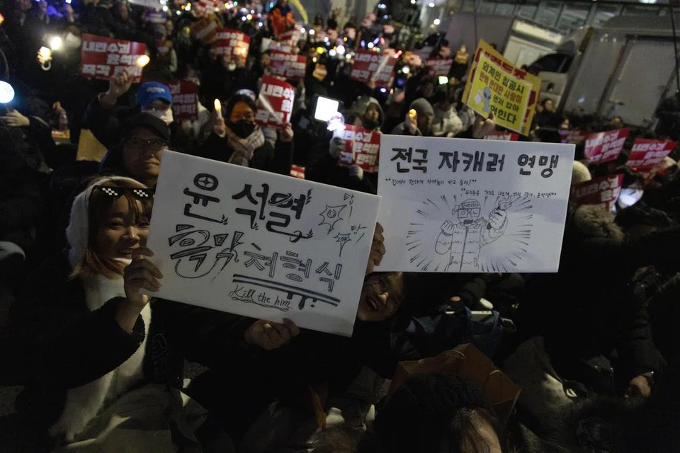 Penunjuk perasaan semasa perhimpunan menyeru pemecatan Presiden Korea Selatan, Encik Yoon Suk Yeol, di luar Dewan Perundangan Kebangsaan di Seoul, pada 9 Disember. Encik Yoon dilarang meninggalkan negara, di tengah-tengah siasatan terhadap pengisytiharan undang-undang tentera pada 3 Disember. 