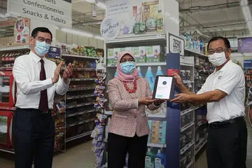 DERMA DALAM TALIAN: Presiden Halimah menyampaikan sumbangan simbolik $40 bagi pihak BBSG dengan mengimbas kod QR menggunakan aplikasi bank. Turut di acara tersebut ialah Ketua Pegawai Eksekutif (CEO) Kumpulan FairPrice Group, Encik Seah Kian Peng (kanan), dan CEO Prudential Singapura, Encik Dennis Tan Namun, sumbangan $40 itu bukan jumlah sebenar yang didermakan Puan Halimah. Menurut The Boys' Brigade, Puan Halimah berikrar menderma kepada 200 penerima bantuan BBSG apabila menerima undangan ke acara pelancaran itu. - Foto BH oleh TIMOTHY DAVID.