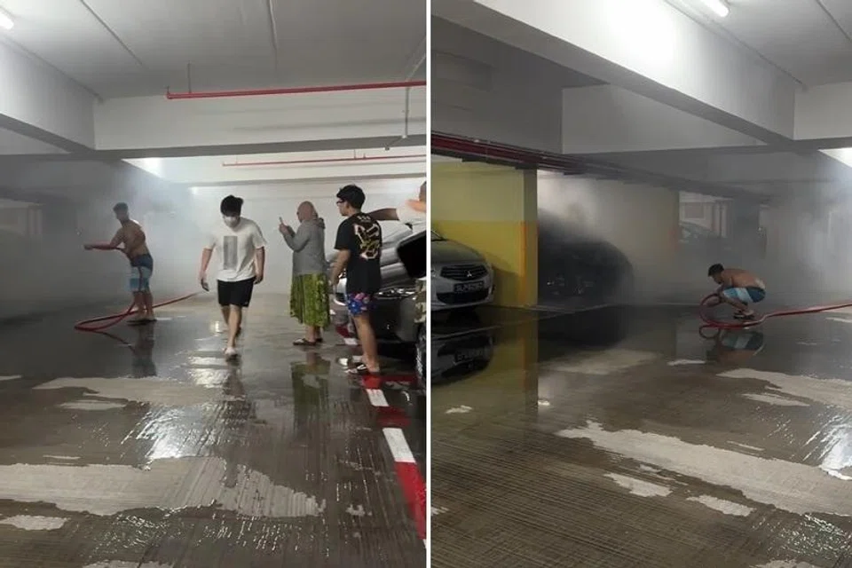 Encik Fahil Ashraff (tidak berbaju), kelihatan menggunakan paip air bomba untuk memadamkan api di sebuah kereta.