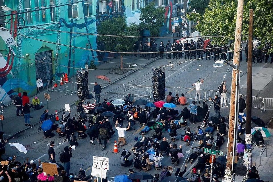 BANTAHAN TERUS BERLAKU: Sekumpulan penunjuk perasaan melutut di kawasan Seattle, Washington, kelmarin bagi membantah kematian Encik Floyd setelah seorang pegawai polis Minneapolis melutut di lehernya hampir sembilan minit pada 25 Mei. - Foto REUTERS